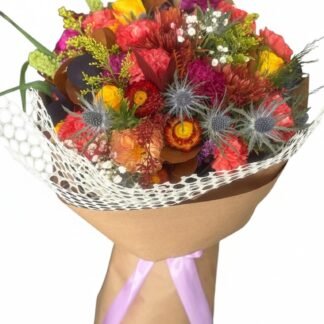 Golden Meadow Bouquet - golden yellow, coral, and peach floral arrangement with calla lilies and roses in a sage green ceramic vase