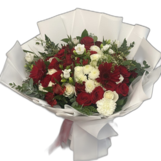 Red rose bouquet wrapped in black paper with white trim and red ribbon
